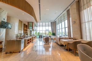 张掖公航旅·祁连明珠酒店的餐厅设有桌椅和大窗户。
