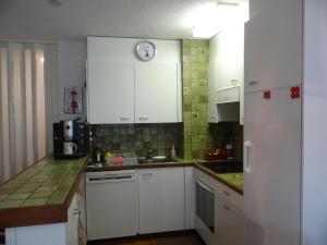 英格堡Apartment Zügstrasse 4 by Interhome的厨房配有白色橱柜和墙上的时钟