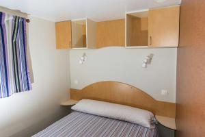 NavecesCamping Las Gaviotas的小房间设有一张床和木制橱柜