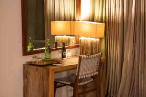 Begūr卡弗萨夫里卡比尼酒店的一张桌子、一盏灯、一把椅子和一面镜子