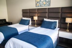 德班The Cato Suites Hotel的酒店客房 - 带两张带蓝色枕头的床