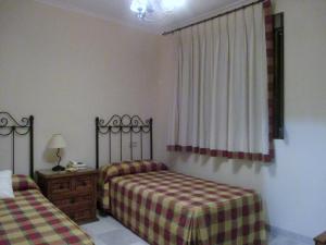 AlboreaHostal Artiga的一间卧室设有两张单人床和一个窗户。