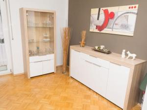 多瑙艾辛根Ferienwohnung Lemke的厨房铺有木地板,配有白色橱柜。