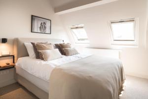 阿姆斯特丹Empire suites garden view的白色卧室配有一张带枕头的大白色床
