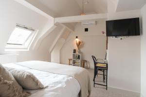 阿姆斯特丹Empire suites garden view的卧室配有一张床,墙上配有电视。