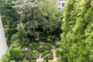 阿姆斯特丹Empire suites garden view的享有花园的顶部景致,花园内种有树木和灌木