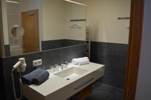 费斯Hotel Garni Frommes的浴室设有白色水槽和镜子