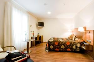 穆尔西亚埃尔楚拉酒店的配有一张床和一张书桌的酒店客房