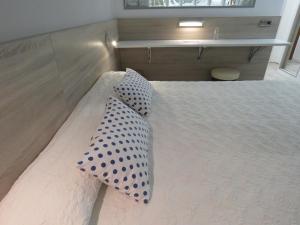 埃斯塔蒂特圣安娜酒店的一张白色的床,上面有波尔卡点枕头