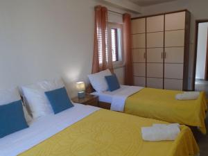 巴斯卡Apartment Antica的一间卧室设有两张黄色和蓝色的床