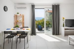 拉巴克Lemechi Casa Girasole Apartments的白色的用餐室配有桌椅和窗户。