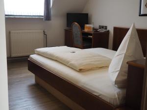 科尔申布罗赫比勒费尔德酒店的一间卧室配有一张床和一张带电脑的书桌