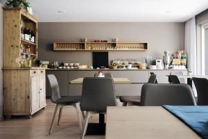 梅拉诺Pension Appartment Hecherhof的一间带桌椅和柜台的餐厅