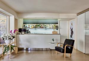 里米尼Hotel La Fenice的一间酒吧,位于带柜台和椅子的房间内