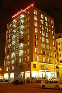 塞拉莱Alpha Suites Hotel的一座建筑物,上面有夜间标志