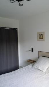 尚皮涅Le 10 Bis的卧室配有一张白色的床和黑色的门
