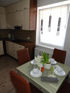 维尔卡瑟Bajka Anity的厨房配有带盘子和鲜花的桌子