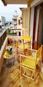 坎皮卡福特Gerret的阳台设有黄色椅子和桌子,享有海景。