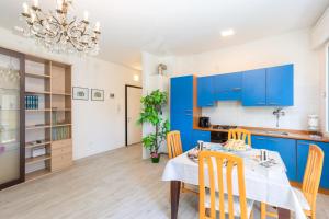 梅斯特塞雷尼斯玛公寓的厨房以及带蓝色橱柜和桌椅的用餐室。