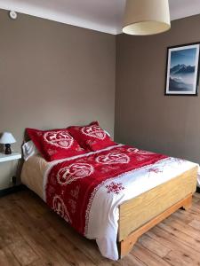 Condamine-ChâtelardLa Condaminoise的一间卧室配有一张带红色枕头的床