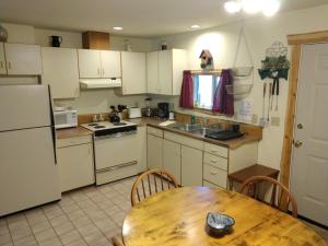 帕克伍德Hall Creek Cabin的厨房配有白色家电和木桌