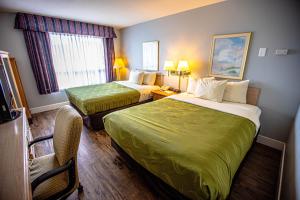 洋滨市Ocean Paradise Hotel & Resort的酒店客房,配有两张床和椅子