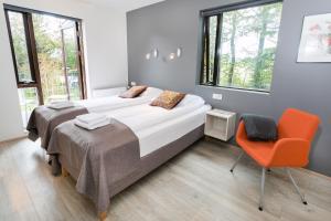 Laugaras布莱库盖尔提住宿加早餐旅馆的一间卧室配有两张床和橙色椅子