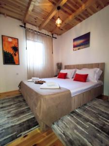 乌尔齐尼Cottage Ajna - Ada Bojana的一间卧室配有一张带红色枕头的大床