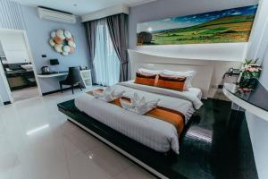 坤敬曼特拉瓦雷酒店的一间卧室配有一张大床和一张书桌