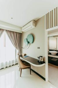 坤敬曼特拉瓦雷酒店的配有桌子、椅子和镜子的房间