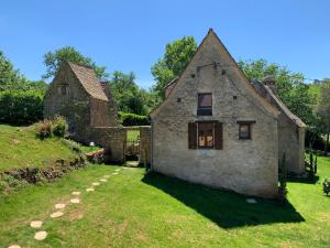 勒比格Gîte - Le Reclaud du Noyer的一座古老的石头房子,设有窗户和庭院