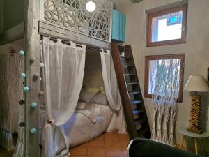 利克维Le gite de Coco的客房设有带窗帘和梯子的双层床。