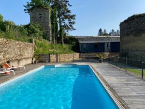 迪南Maison d'hôtes & Gîtes Domaine de la Garaye的蓝色的游泳池,设有木甲板和一座建筑