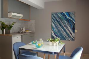 波罗斯ALKYONI Studios Poros Kefalonia的厨房配有白色的桌子和蓝色的椅子