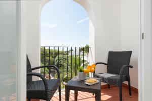 卡拉达沃Hostal Talamanca的阳台配有椅子和一张桌子,上面有橙子
