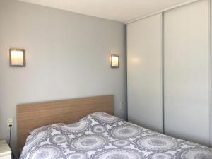 勒伯吉特杜拉克RESIDENCE DU PORT的卧室配有一张床,墙上有两盏灯