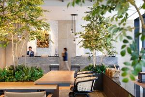 大阪Miyako City Osaka Hommachi的一间设有木桌和椅子的餐厅