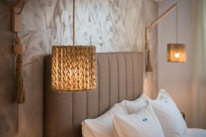 阿达玛斯坡提尼酒店的一间卧室配有一张带两盏灯和两个枕头的床。