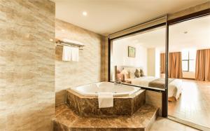 格卢市社孟青格兰德库阿尔酒店的带浴缸的大浴室和卧室