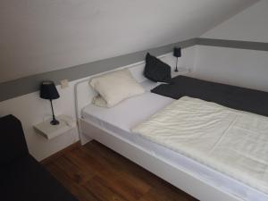 Rengsdorf沃尔德大街酒店的一间小卧室,配有一张白色的床和两盏灯