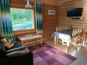 普马拉Lappalaisen lomamökit Mäntypirtti的小屋内的客厅配有桌子和电视