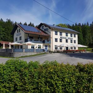 林德伯格Zur Alten Dampfsäge - Gasthaus-Pension Weber的一座白色的大建筑,前面设有桌椅