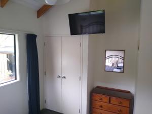 凯里凯里凯里谷德小屋汽车旅馆的卧室设有壁挂式电视和梳妆台