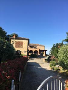 渥尔特拉Agriturismo Casale Giulia的通往带围栏的房子的道路