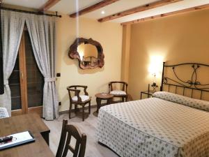 塞普尔韦达Hotel Rural & SPA Puente del Duratón的卧室配有一张床和一张桌子及椅子