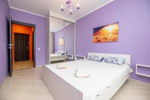 喀山Apartment on Khakima 50的紫色卧室配有一张大床和镜子