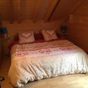 莱托利Chalet le Grizzly的一间卧室配有一张带粉色和白色毯子及枕头的床。