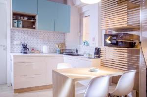 萨格勒布马克西米1号苏伯公寓的厨房配有木桌和白色橱柜。