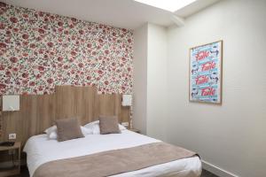 阿姆博斯Logis Hôtel Restaurant Lanex Amboise的一间卧室设有一张带花卉墙壁的大床