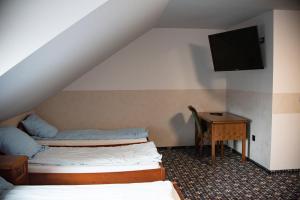 KroczyceStacja Jura的客房设有两张床、一张桌子和一台电视机。
